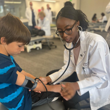 Student doctor takes vitals of elementary school patient