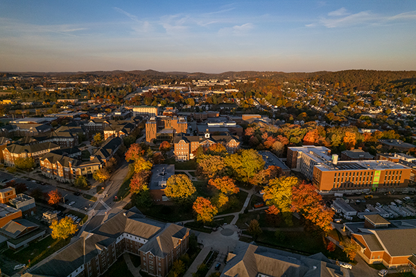 Aerial view of IUP campus on a sunny fall day. A mountain is in the background.