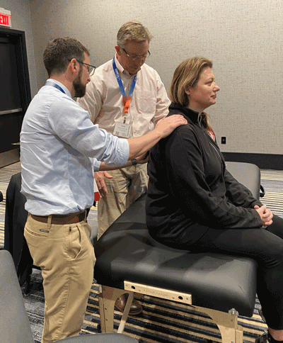 Doctor demonstrating an OMT treatment to a colleague