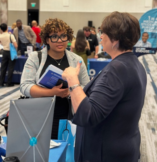 Advisor speaks with a prospective medical student at a COM Recruitment Fair