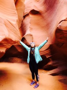 Vivi standing in a canyon, arms outstretched