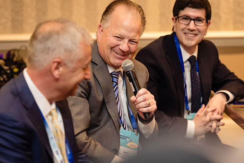 Group of conference attendees, one is asking a question