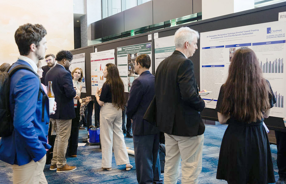 EL25-250409LHG_1065 Attendees viewing research posters and discussing them.