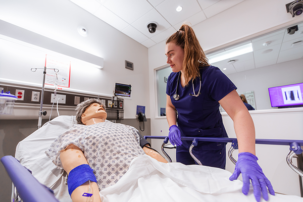 DMU-COM student with simulated patient