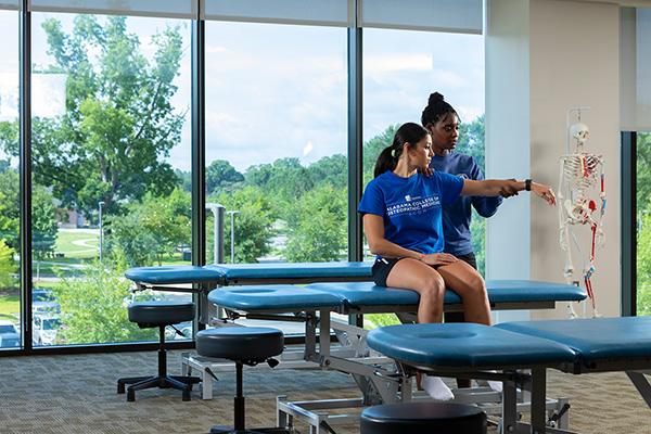 Two ACOM students practicing OMM in an OMM lab