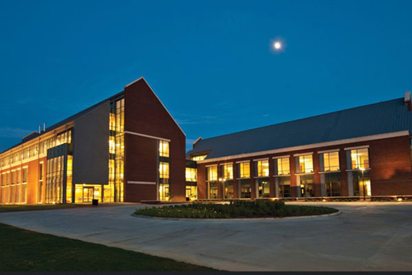 CUSOM campus buildings at night with a full moon overhead.