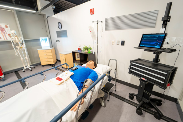 D'Youville Simulation Center with simulated patient lying on a gurney.