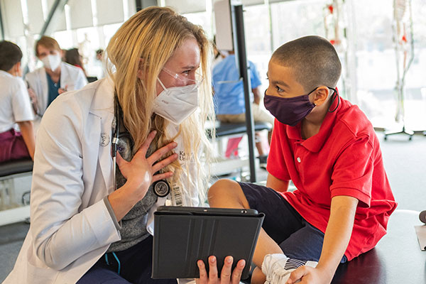 KCU student doctor speaking with a boy