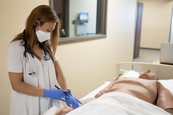 Female student checking pulse on a simulated patient