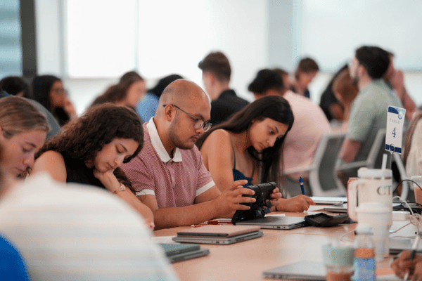 Male and female medical students studying at long tables.