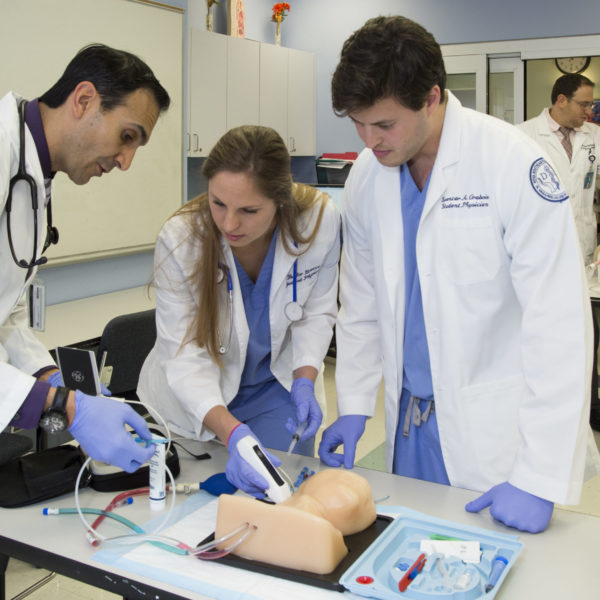 Doctor instructing students in a Simulation classroom