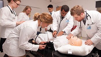 ATSU-KCOM med students treating a simulated patient.