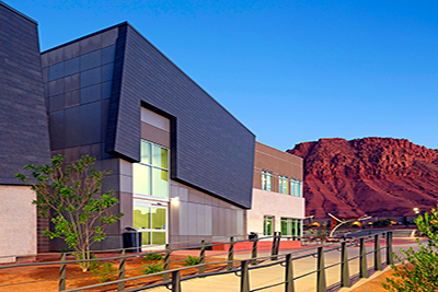 RVU-COM campus building with red mountains in the background