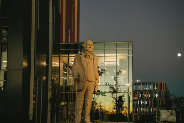 Campus building with Sam statue at night