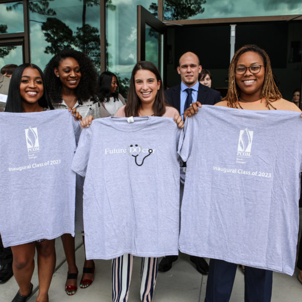 Three med students holding Class of 2023 tee shirts