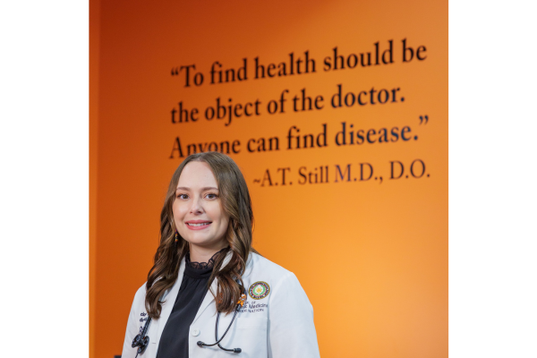 Mackenzee posing in front of an A.T. Still quote. Photo Courtesy of Oklahoma State University