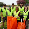 AgroupofIdahoCollegeofOsteopathicMedicineICOMstudentsandstaffinreflectivevestsholdorangegarbagebagsduringacommunitycleanupactivity