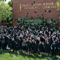 GraduatesfromtheWestVirginiaSchoolofOsteopathicMedicinecelebratebytossingtheircapsintheairoutsidetheschoolbuilding