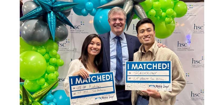 Two students hold “I MATCHED!” signs alongside a faculty member during Match Day celebrations.