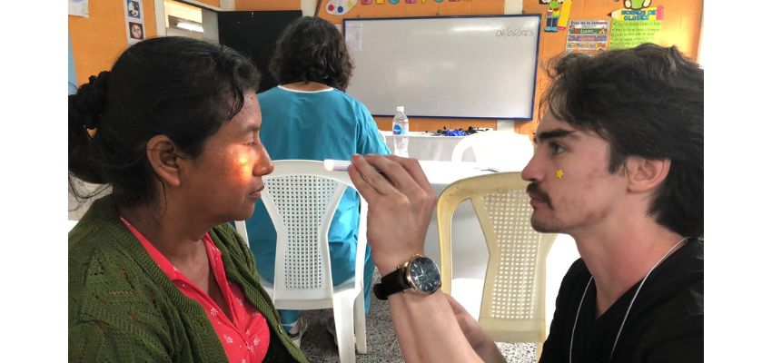 Student doctor Kory performs an eye exam in a community clinic setting
