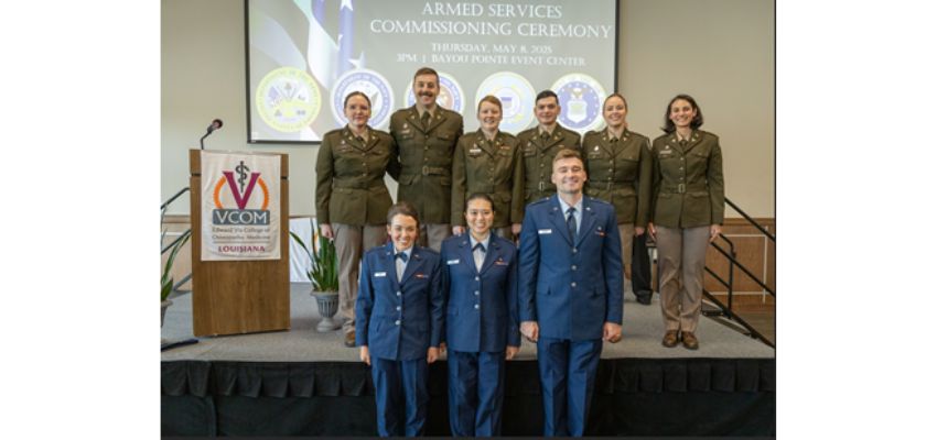 Uniformed students pose onstage during the Armed Services Commissioning Ceremony at VCOM-Louisiana.