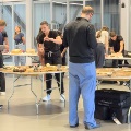 Medicalstudentsinscrubsandbusinesscasualattiregatheraroundtablesengaginginhands-onactivitiesinsideamodernfacility