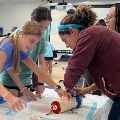 Studentsworktogetheronamedicalsimulationarminaclassroompracticingclinicalskillswithfocusandteamwork