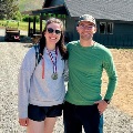 Twopeopleoutdoorssmilingforaphotoonewearingamedalsuggestingparticipationinanoutdooreventorcompetition