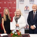 FivepeoplestandinfrontofCentenaryCollegeandVCOMLouisianabannersholdingasigneddocumentataformalevent