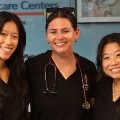 AtPCOMsCommunityDayeventthreefemalemedicalstudentswithdarkhairandwearingblackscrubssmileforthecamera