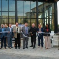 Agroupofleadersandfacultycutaribboninfrontofaglassbuildingduringaribbon-cuttingceremony