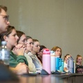 Studentssitattentivelyinalecturehallfocusedonapresentationatthefrontoftheroom