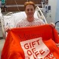 MatthewsitsinahospitalbedafterprovidingbonemarrowholdingupabrightorangeGiftofLifeblanket