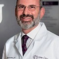 DrHahnsmilesinaprofessionalenvironmentwearinghiswhitecoatwithKansasCityUniversityembroideredonit