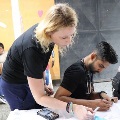 DrReedstandsbehindastudentinstructinghimhowtoperformthetask