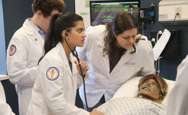 Students assess symptoms of practice manikin