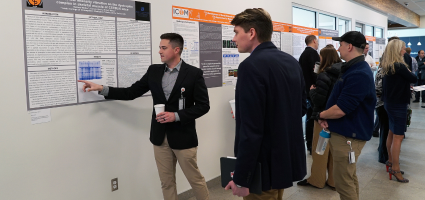 Student points to his research poster