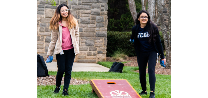 Two students playing cornhole