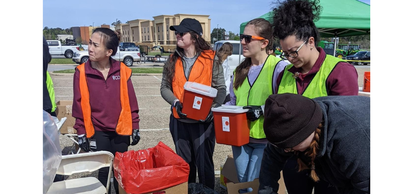 Students hold waste disposal containers