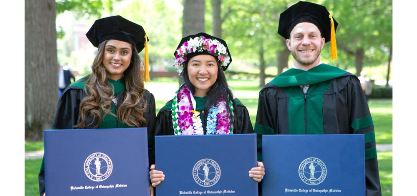 Students outside holding diplomas