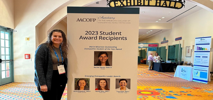 Amanda standing next to awards sign in Orlando exhibit hall.