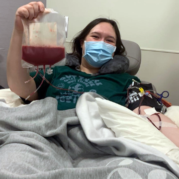 Madison in a hospital bed holding stem sell donation.