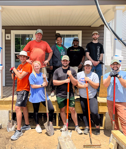 VCOM Virginia students pose in front of the house they were fixing up for Habitat for Humanity