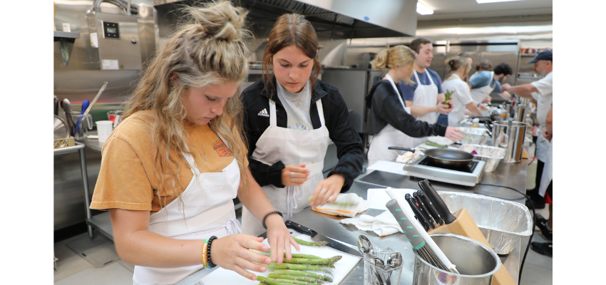 Students learn how to prepare asparagus in cooking class