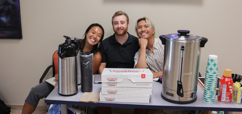 Students sit at table with donuts and coffee