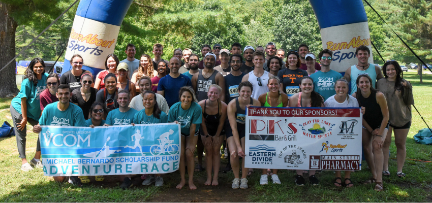 Students outdoors hold banners for the adventure race