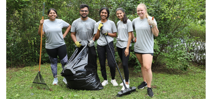 Five WVSOM students raking and clearing out a backyard