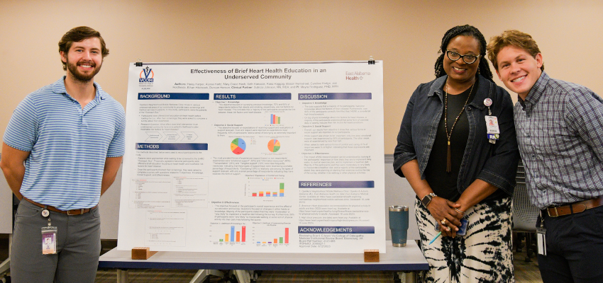 Students stand in front of their award winning research poster