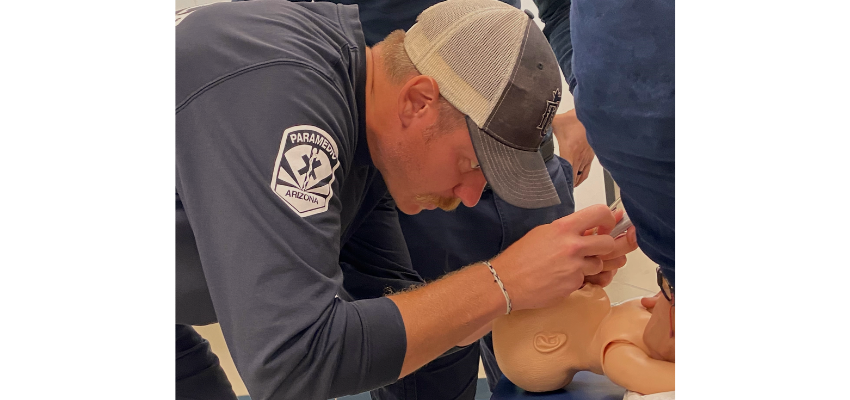 Firefighter intubates child manikin
