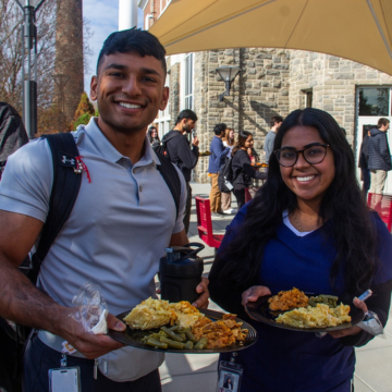 Two students with plates of Thanksgiving classics